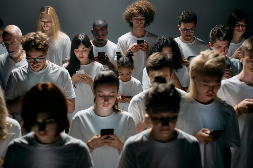 Menschen in einer Gruppe, die konzentriert auf ihre Smartphones schauen – Symbolbild für Dopaminsucht und Social-Media-Sucht.